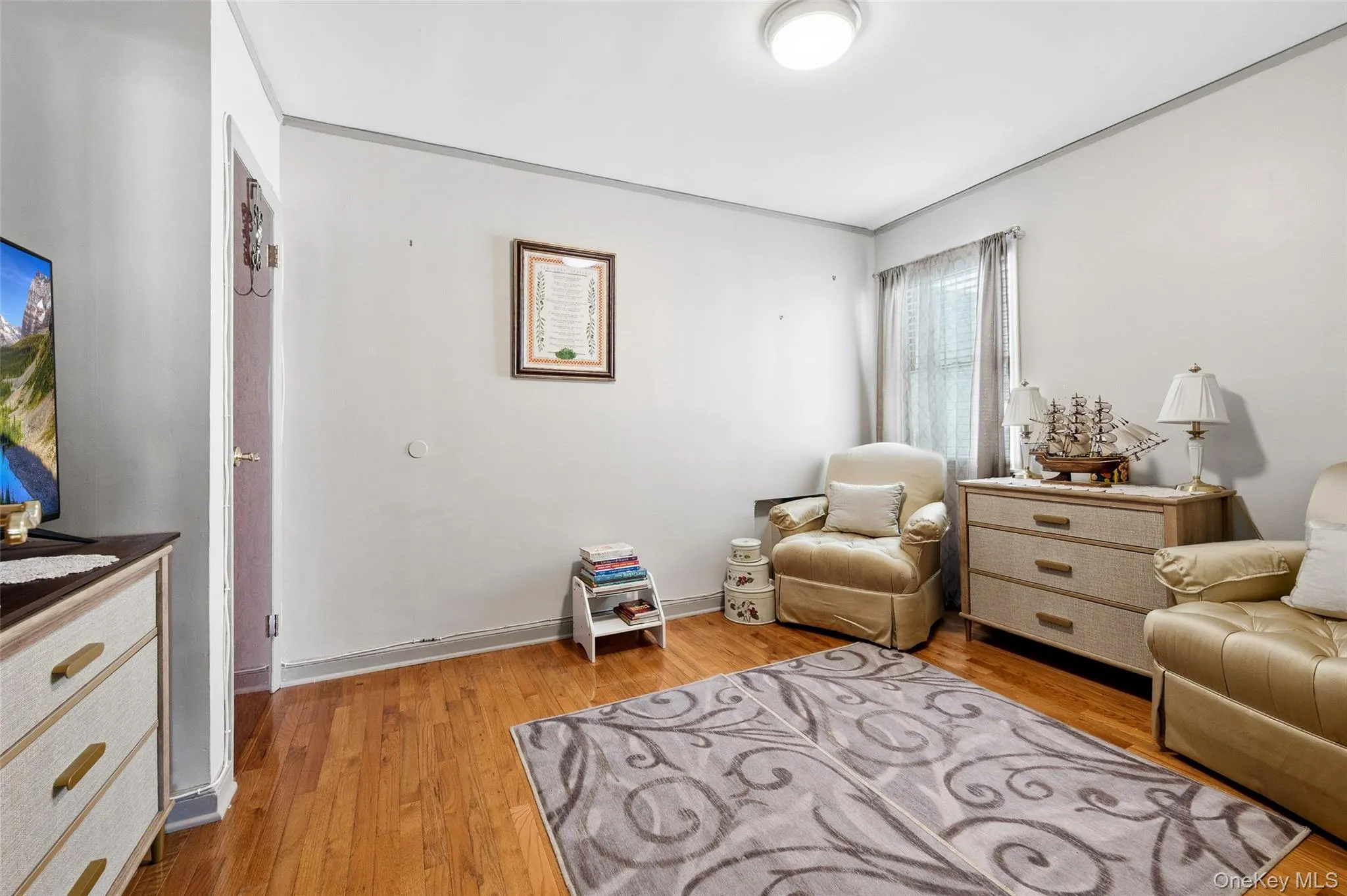 Hardwood flooring throughout featuring a window with natural light, a ceiling-mounted light fixture, and a solid door frame Hardwood flooring throughout featuring a window with natural light, a ceiling-mounted light fixture, and a solid door frame