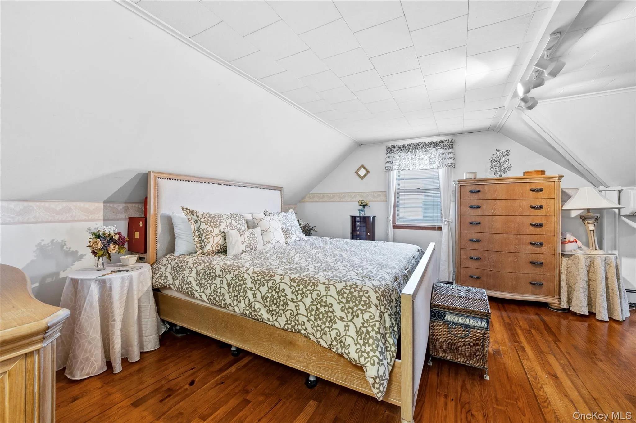 Hardwood flooring complements a neutral wall color and sloped ceiling Hardwood flooring complements a neutral wall color and sloped ceiling