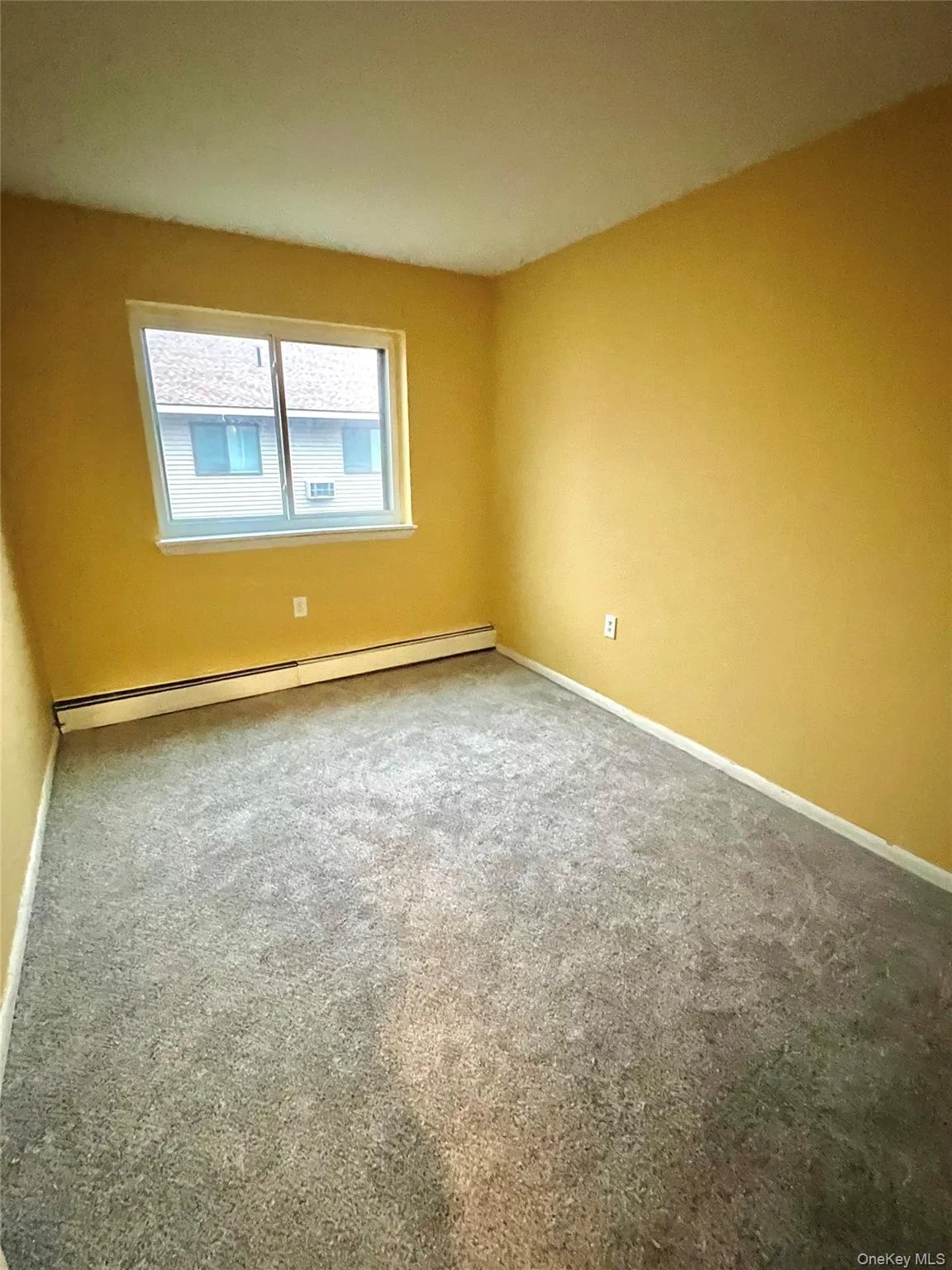 Carpeted spare room with baseboards and baseboard heating Carpeted spare room with baseboards and baseboard heating