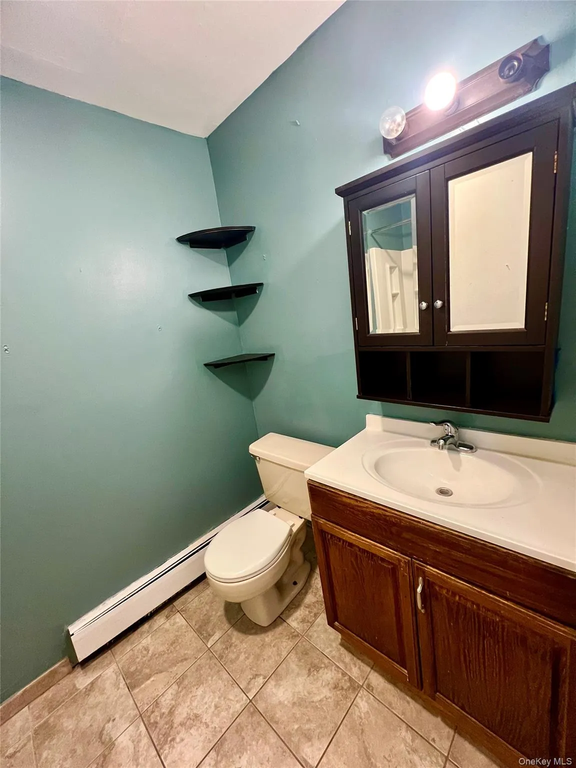 Half bathroom featuring vanity and light tile patterned flooring Half bathroom featuring vanity and light tile patterned flooring