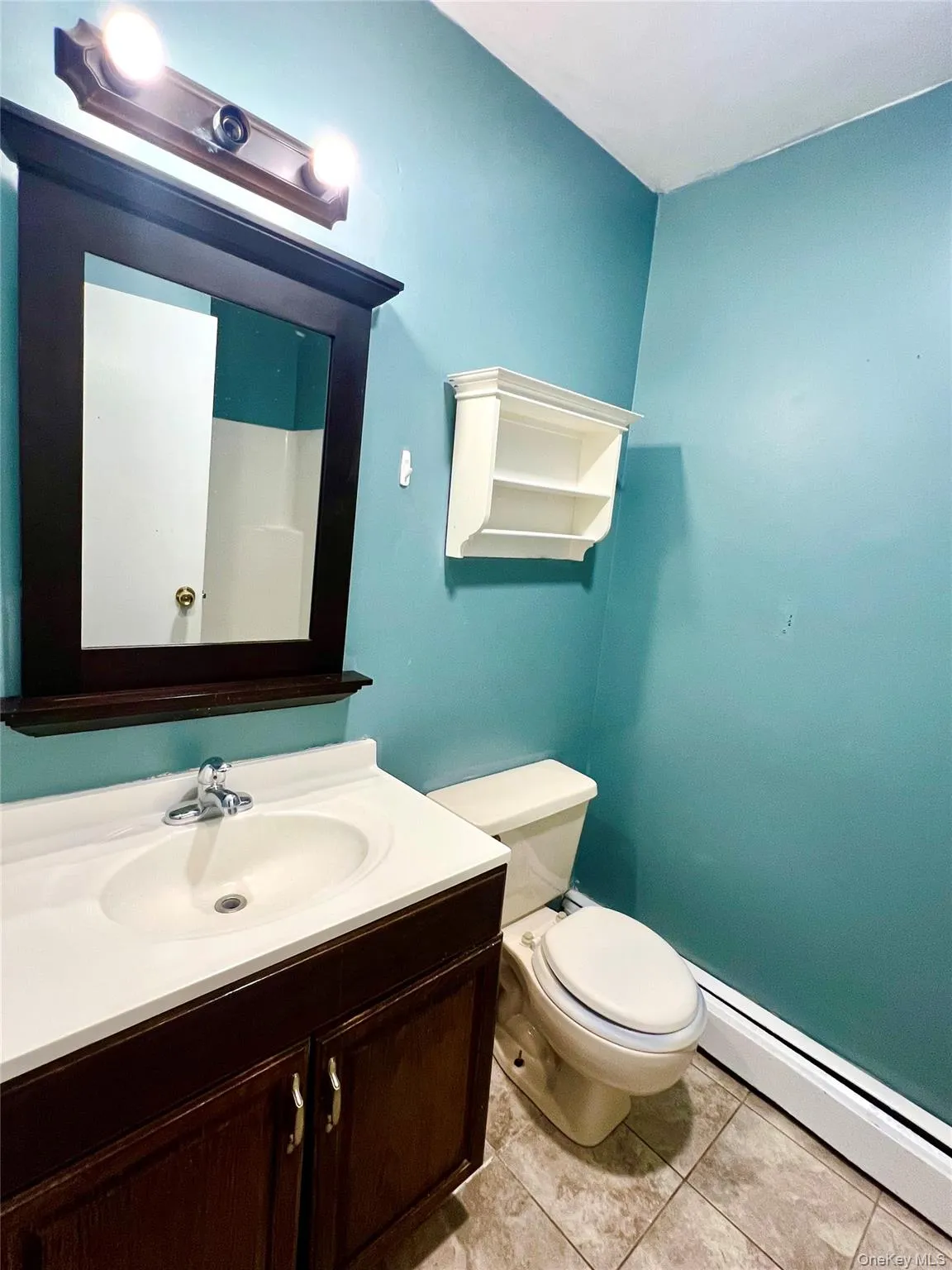 Half bathroom with baseboard heating, light tile patterned floors, and vanity Half bathroom with baseboard heating, light tile patterned floors, and vanity