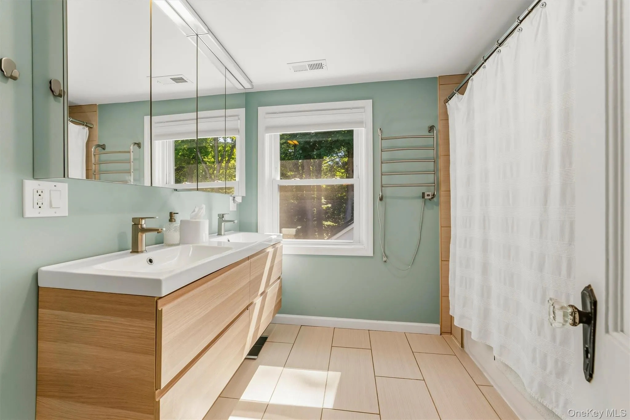 Modern vanity with dual integrated sinks, gold-tone faucets, and recessed medicine cabinets Modern vanity with dual integrated sinks, gold-tone faucets, and recessed medicine cabinets