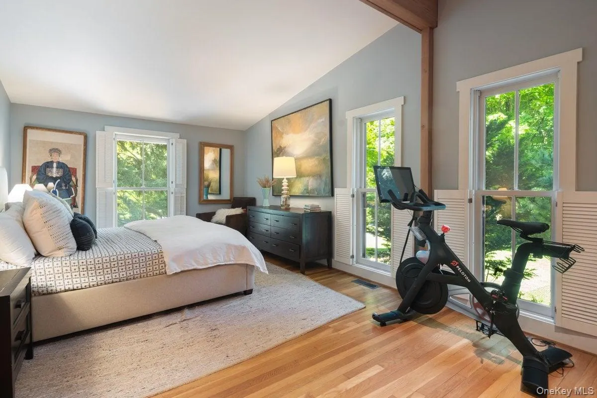 Spacious and serene, the primary bedroom is anchored by oversized windows and highlighted by vaulted ceilings with natural wood beams. A true welcome escape. Spacious and serene, the primary bedroom is anchored by oversized windows and highlighted by vaulted ceilings with natural wood beams. A true welcome escape.