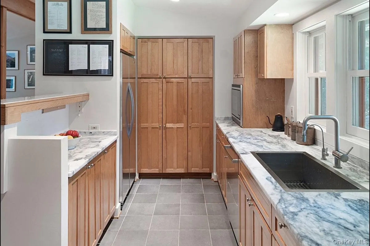 The KitchenAid stainless steel refrigerator is tucked in and blends seamlessly, while the wall of pantry provides ample and convenient storage. The KitchenAid stainless steel refrigerator is tucked in and blends seamlessly, while the wall of pantry provides ample and convenient storage.