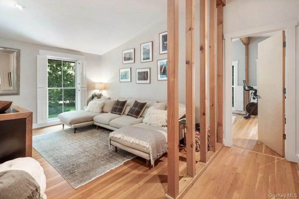 View into the den and the primary bedroom at the end of the hall, where the distinct open wood wall highlights the space. View into the den and the primary bedroom at the end of the hall, where the distinct open wood wall highlights the space.