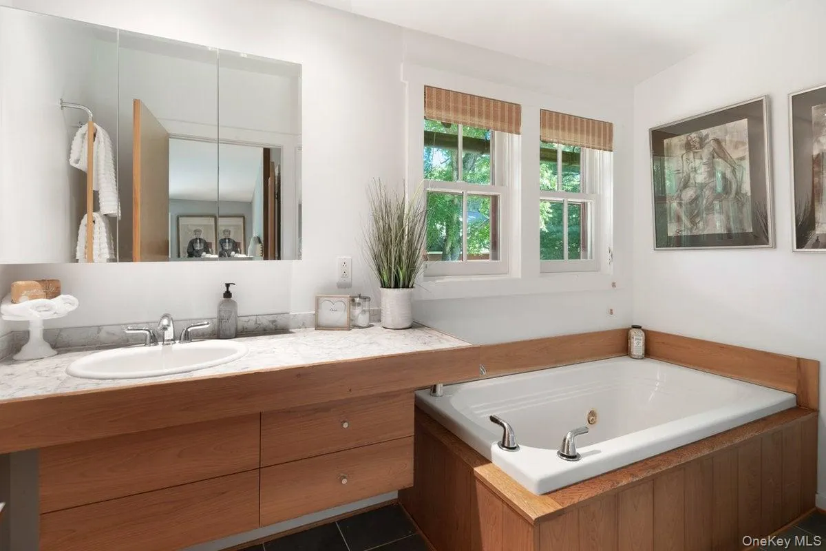 The primary bath offers a true spa experience with a jacuzzi soaking tub. A separate stand-up shower, floating vanity, and large windows enhance the space. The primary bath offers a true spa experience with a jacuzzi soaking tub. A separate stand-up shower, floating vanity, and large windows enhance the space.