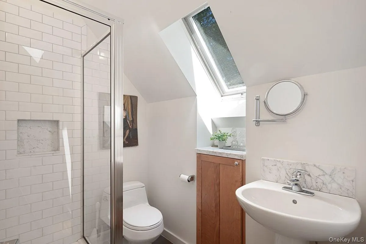 Full bath on the second floor with a stand-up shower, window, and pedestal sink is shared by the two bedrooms. Full bath on the second floor with a stand-up shower, window, and pedestal sink is shared by the two bedrooms.