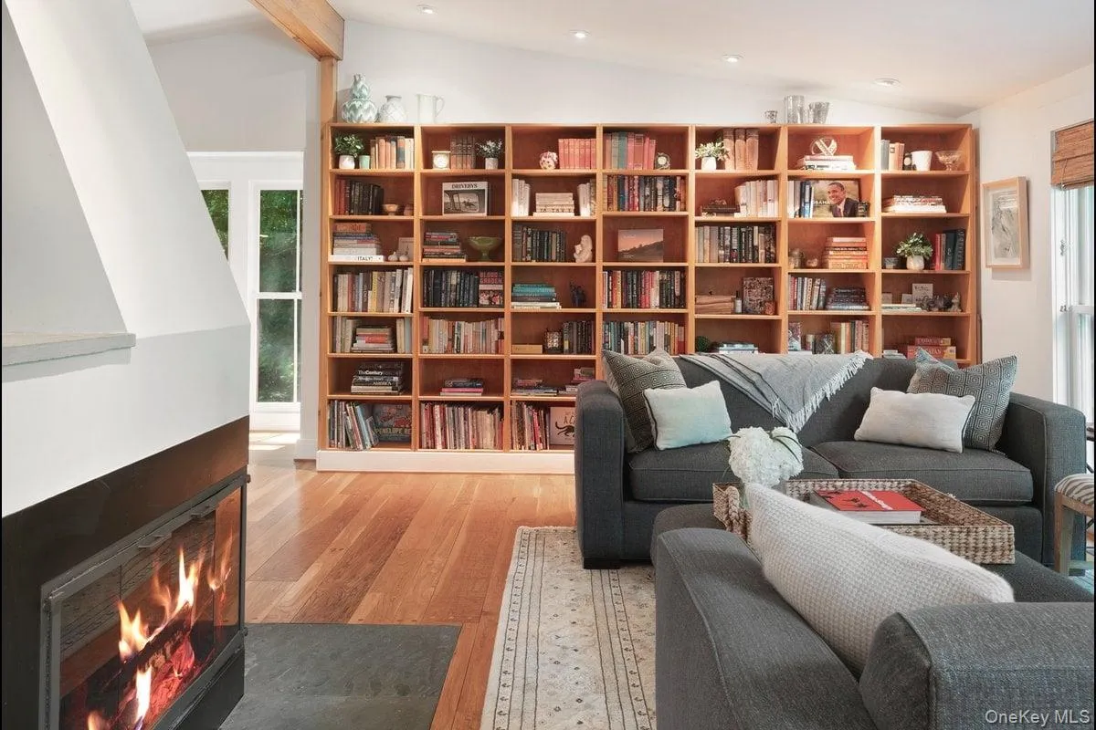 A wall of custom wood bookcases in the living room blends seamlessly, creating the perfect showcase for your book collection. A wall of custom wood bookcases in the living room blends seamlessly, creating the perfect showcase for your book collection.