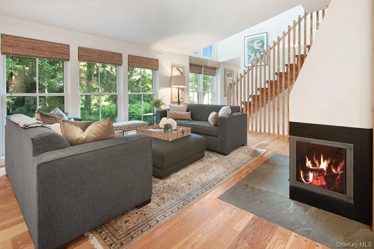 A wall of windows anchors the living room, while a wood-burning fireplace serves as a cozy focal point. The stairs to the second floor are as beautiful as they are functional. The details don't go unnoticed. A wall of windows anchors the living room, while a wood-burning fireplace serves as a cozy focal point. The stairs to the second floor are as beautiful as they are functional. The details don't go unnoticed.