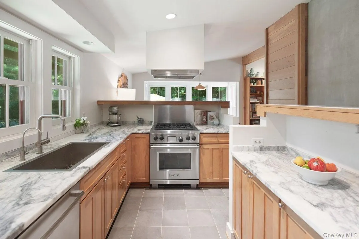 The kitchen, open to the living and dining rooms, features a Wolf range and an abundance of quartz counterspace for the aspiring chef. The kitchen, open to the living and dining rooms, features a Wolf range and an abundance of quartz counterspace for the aspiring chef.