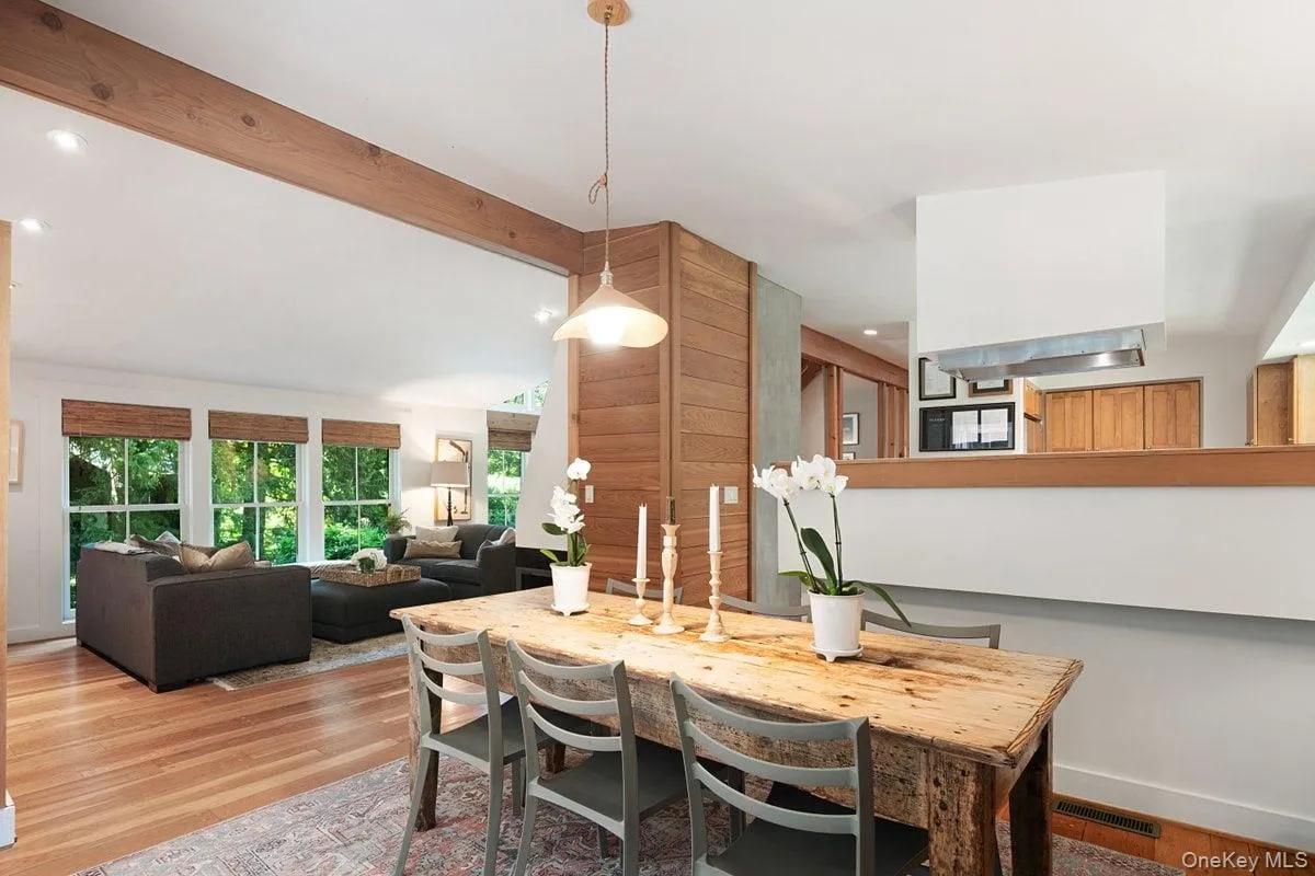 The dining area is just off the living room and kitchen, with wood beams accenting the ceiling and wood details framing the fireplace. The dining area is just off the living room and kitchen, with wood beams accenting the ceiling and wood details framing the fireplace.