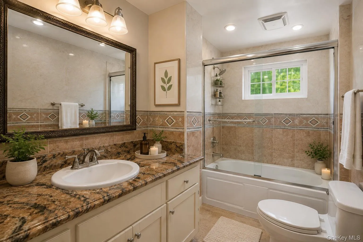 Bathroom with a granite countertop vanity, recessed lighting, a tub/shower combination with a glass enclosure, and decorative wall tiling Bathroom with a granite countertop vanity, recessed lighting, a tub/shower combination with a glass enclosure, and decorative wall tiling