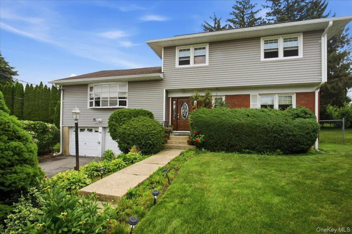 Split-level residence featuring gray siding and a brick facade Split-level residence featuring gray siding and a brick facade