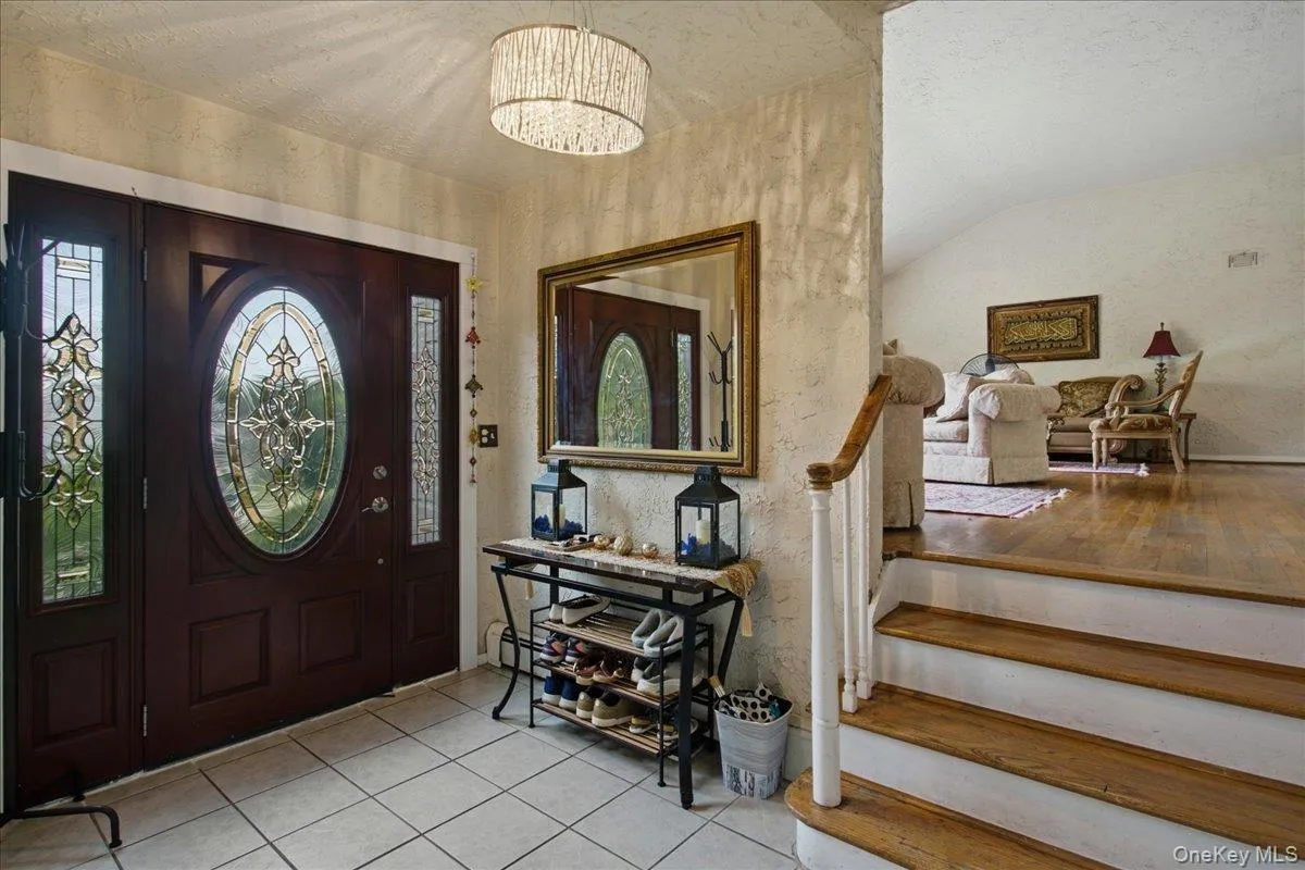 Entryway featuring a dark wood door with oval leaded glass, side panel windows, and a drum-style chandelier Entryway featuring a dark wood door with oval leaded glass, side panel windows, and a drum-style chandelier