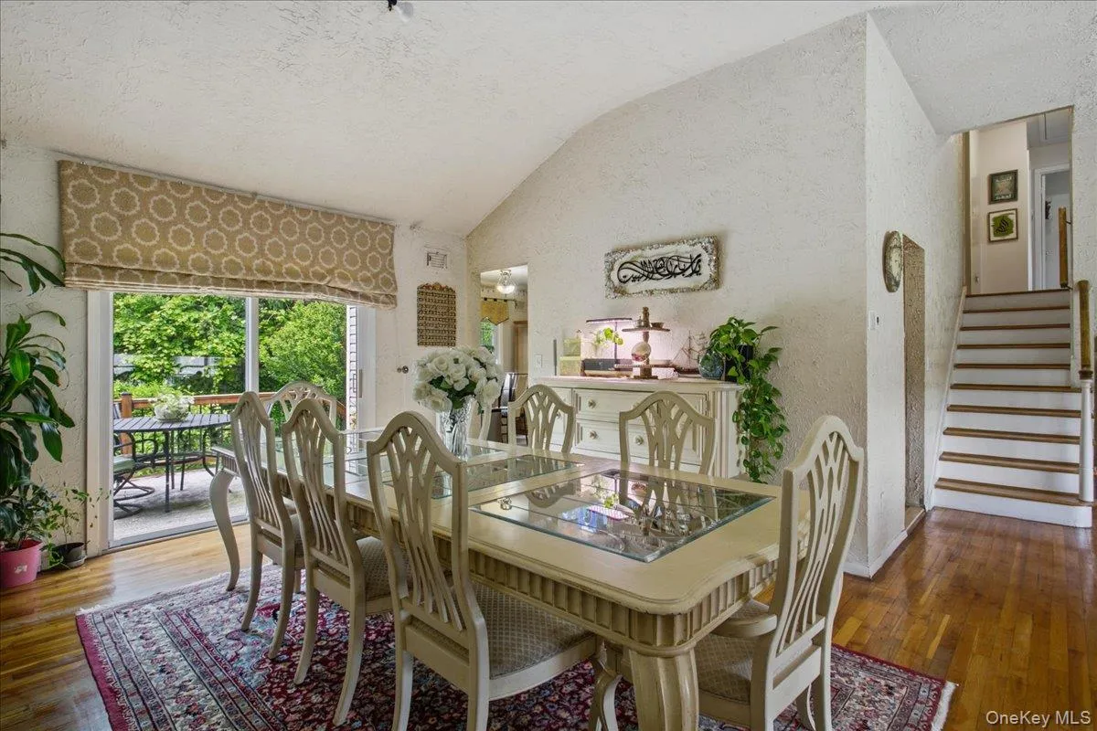 Dining area with vaulted ceiling and wood-finish flooring Dining area with vaulted ceiling and wood-finish flooring