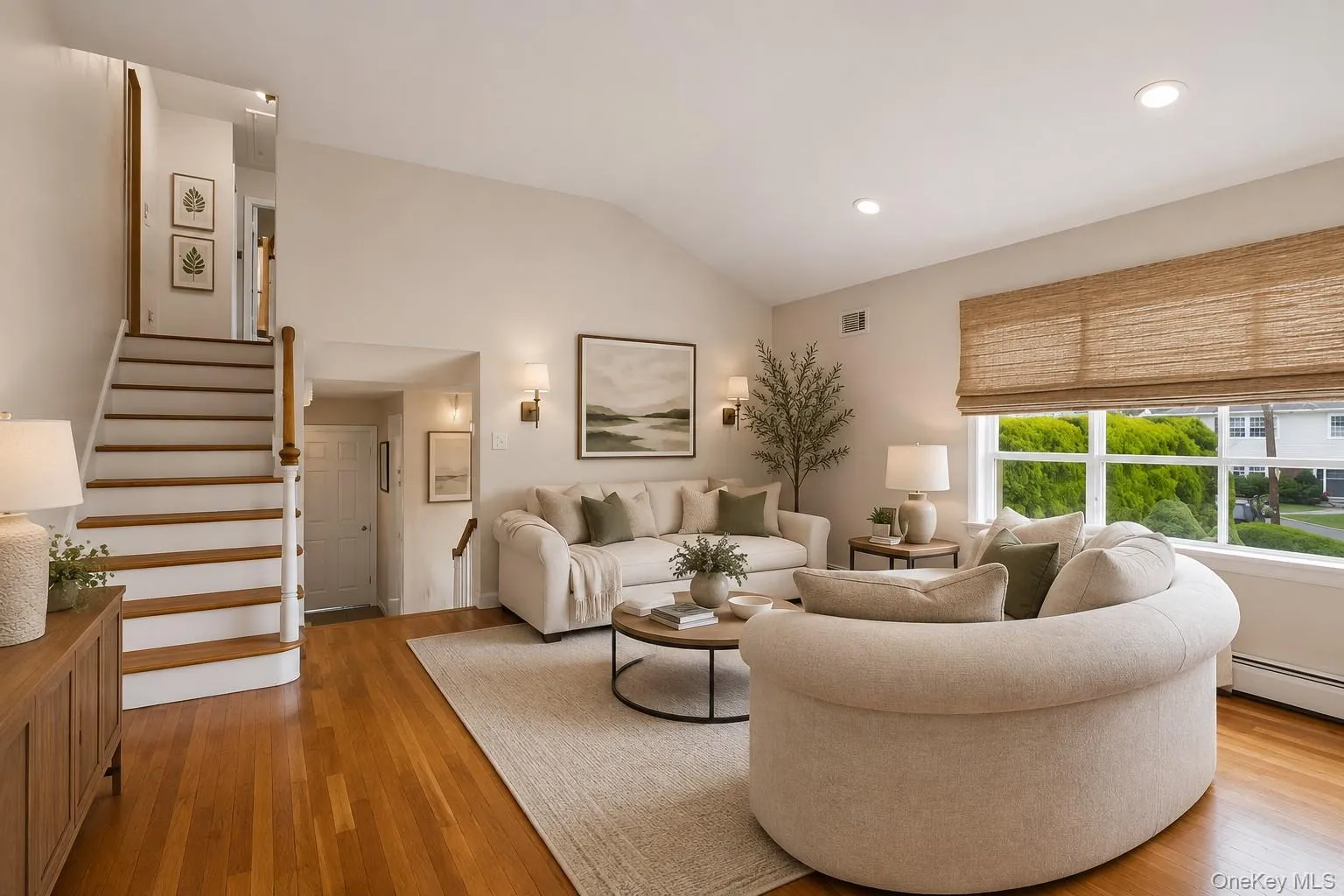 Vaulted ceiling, recessed lighting, wood-finish flooring, staircase with wood handrail, large window with natural light Vaulted ceiling, recessed lighting, wood-finish flooring, staircase with wood handrail, large window with natural light