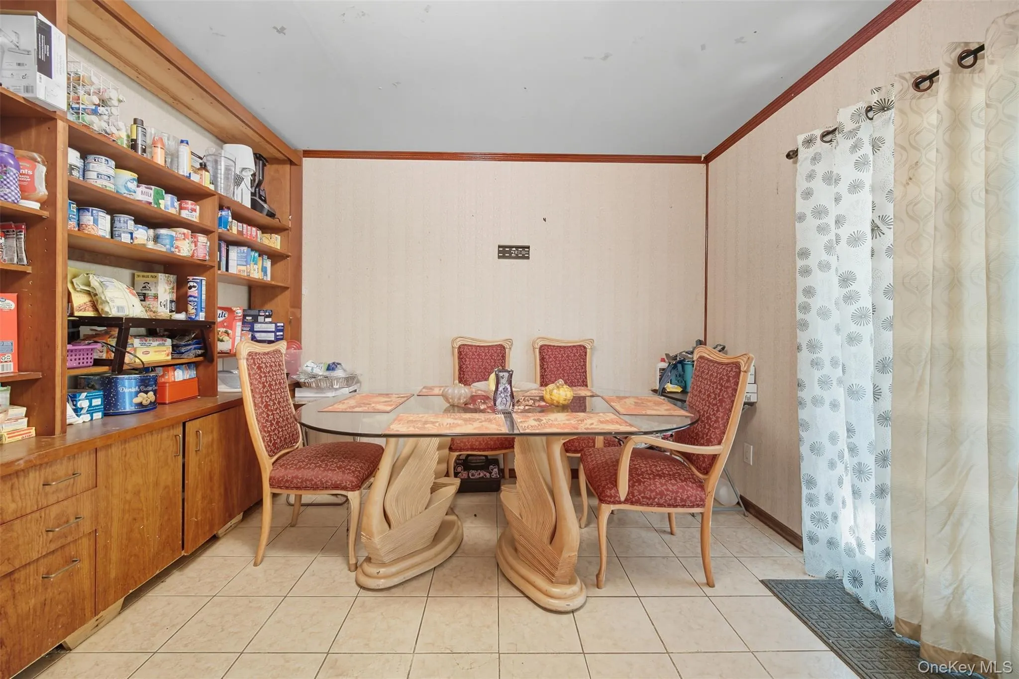 Dining room featuring crown molding and light tile patterned floors Dining room featuring crown molding and light tile patterned floors