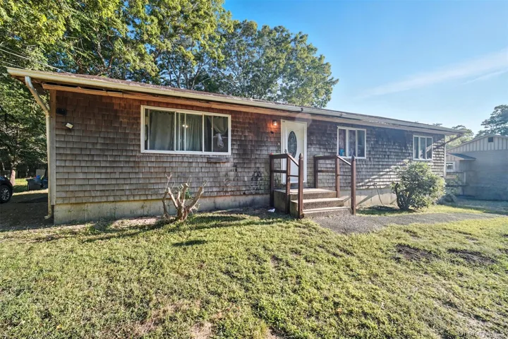 Ranch-style home featuring a front lawn