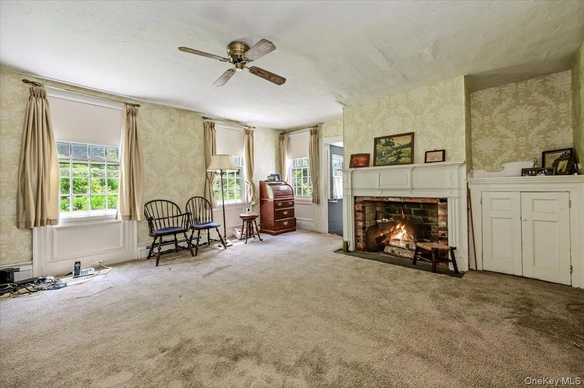 Oversized windows with decorative molding details and brick fireplace. Oversized windows with decorative molding details and brick fireplace.