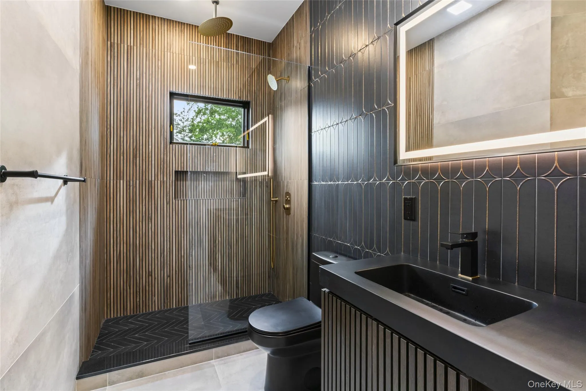 Contemporary bathroom featuring a walk-in shower with a gold-tone rain showerhead, a black toilet, and a vanity with an integrated sink and matte black faucet Contemporary bathroom featuring a walk-in shower with a gold-tone rain showerhead, a black toilet, and a vanity with an integrated sink and matte black faucet