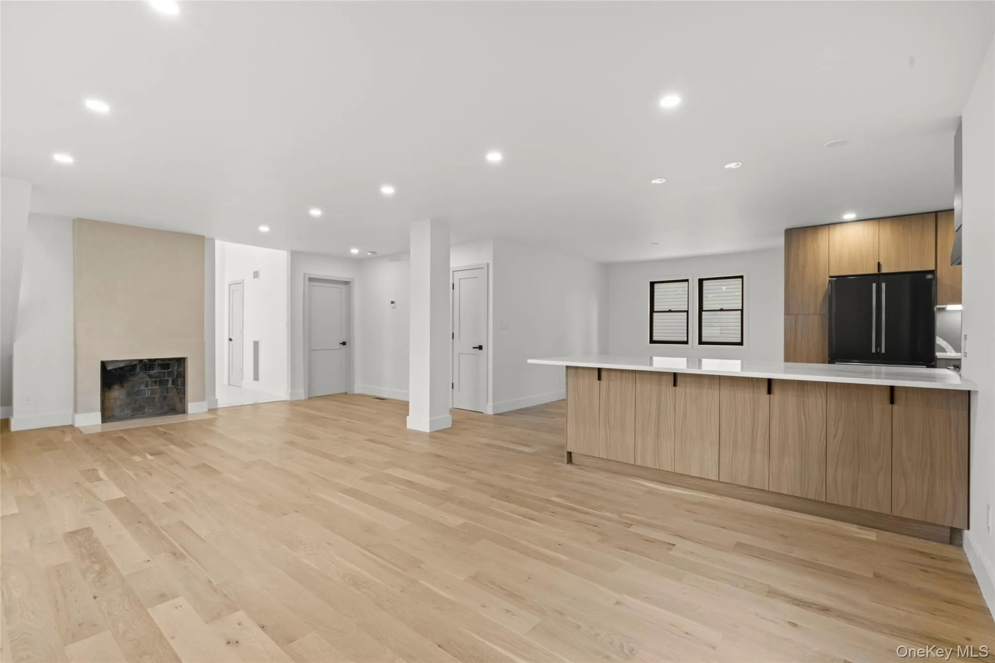 Expansive open-concept living area featuring light wood-finish flooring Expansive open-concept living area featuring light wood-finish flooring