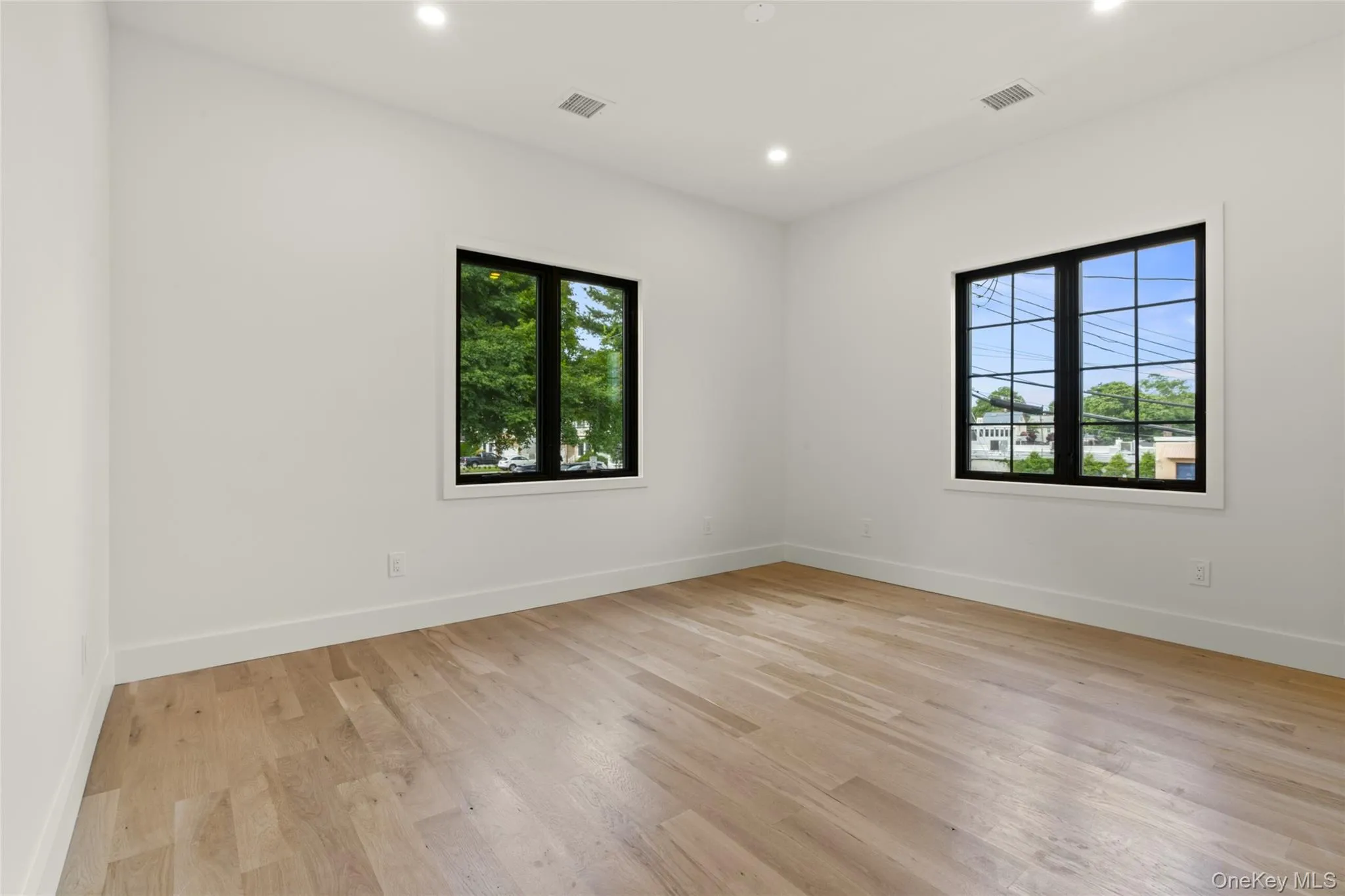 Light wood-finish flooring complements white walls with crisp baseboards Light wood-finish flooring complements white walls with crisp baseboards