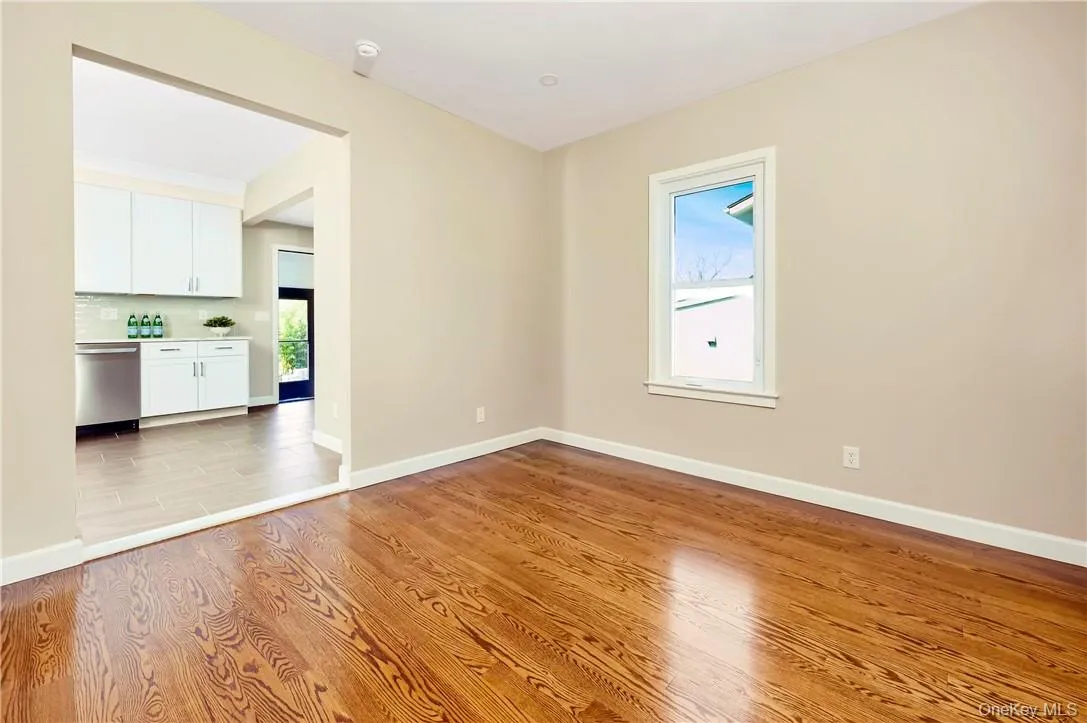 View of the Living Room without furniture. New hardwood throughout. Peek of the kitchen and separate private entrance from the back. View of the Living Room without furniture. New hardwood throughout. Peek of the kitchen and separate private entrance from the back.