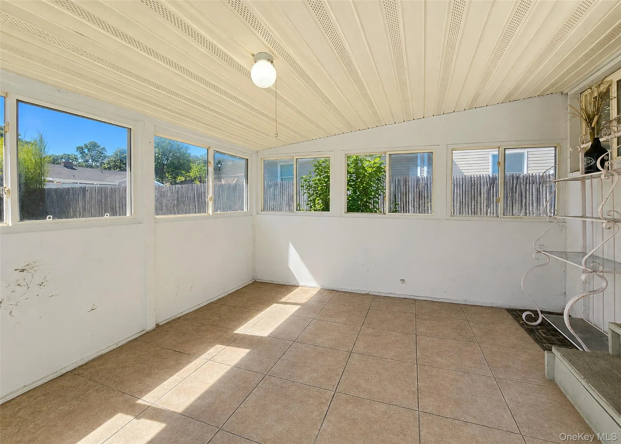 Cozy Sunroom Has Tile Flooring & Plenty Of Windows. Cozy Sunroom Has Tile Flooring & Plenty Of Windows.