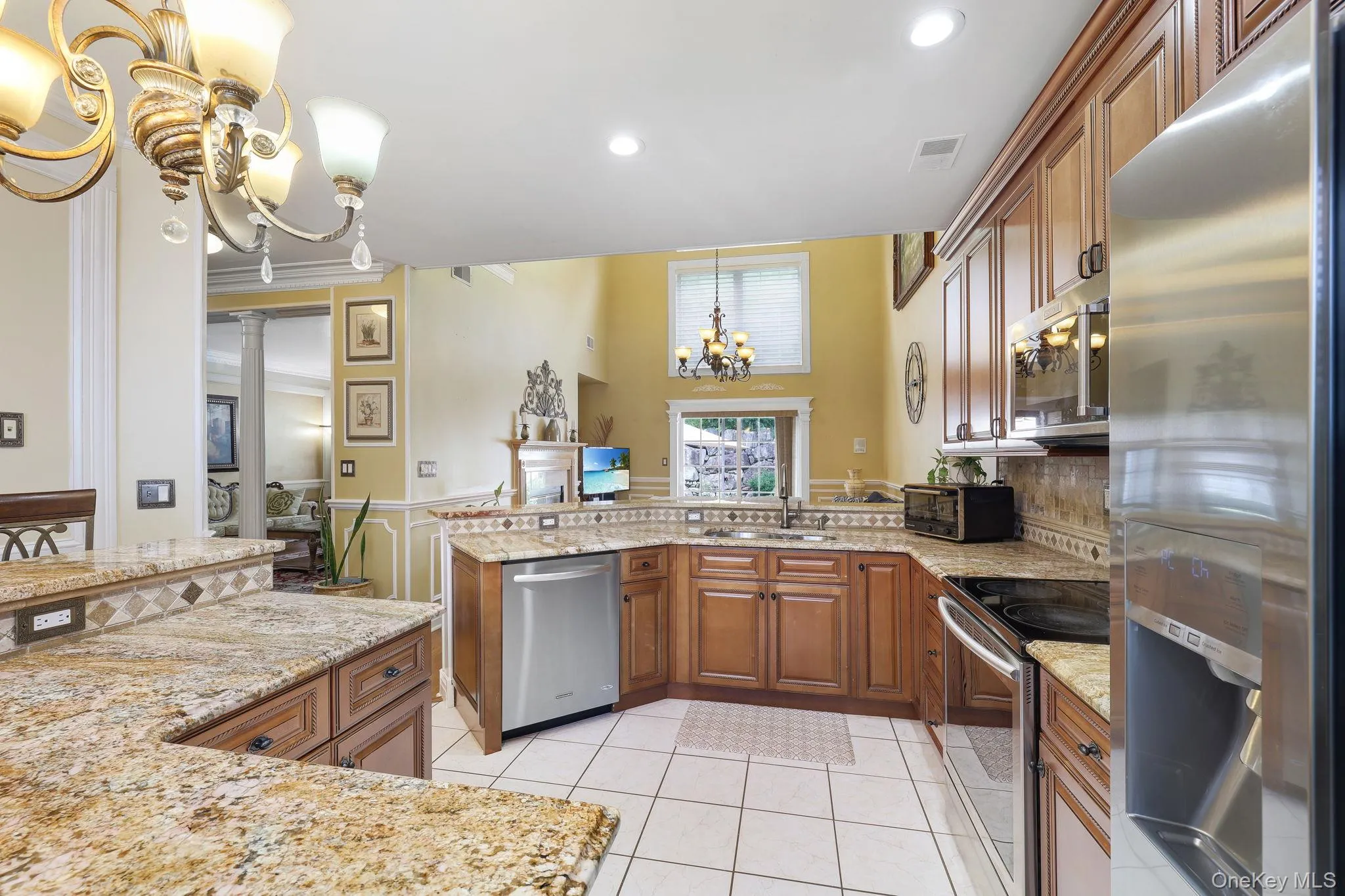 Kitchen featuring light wood cabinetry, granite countertops, tile flooring, and stainless steel appliances Kitchen featuring light wood cabinetry, granite countertops, tile flooring, and stainless steel appliances