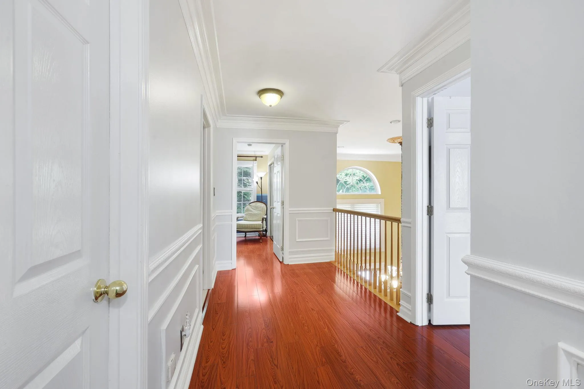 Upstairs spacious hallway featuring wood-finish flooring, wainscoting, crown molding, and recessed lighting and overlooks two story family room Upstairs spacious hallway featuring wood-finish flooring, wainscoting, crown molding, and recessed lighting and overlooks two story family room