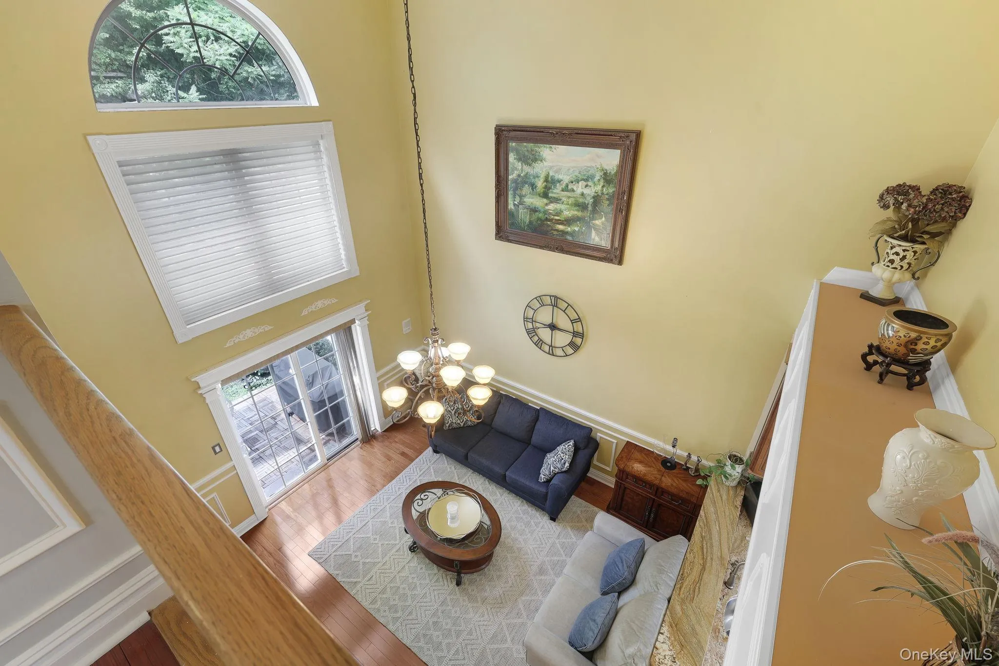 Two-story living area featuring a vaulted ceiling and an arched window Two-story living area featuring a vaulted ceiling and an arched window