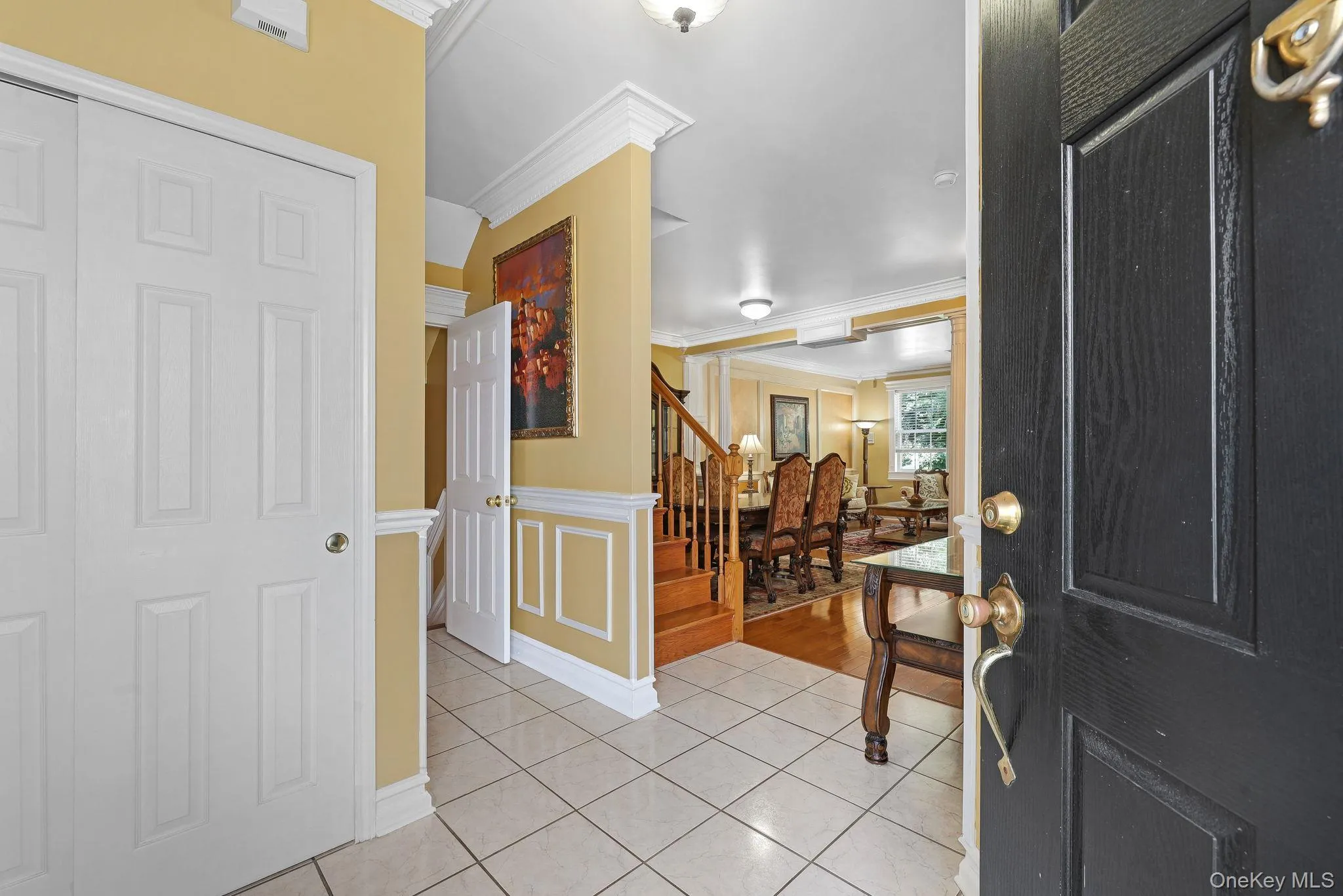 Inviting entry foyer featuring tile flooring, white panel doors, crown molding and convenient access to the finished lower level Inviting entry foyer featuring tile flooring, white panel doors, crown molding and convenient access to the finished lower level