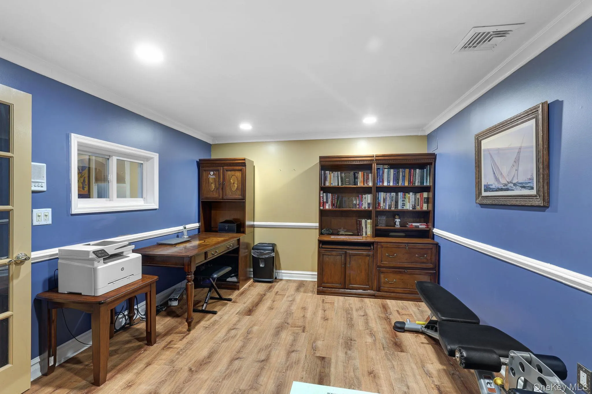 Room featuring wood-finish flooring, recessed lighting, and a white crown molding trim Room featuring wood-finish flooring, recessed lighting, and a white crown molding trim