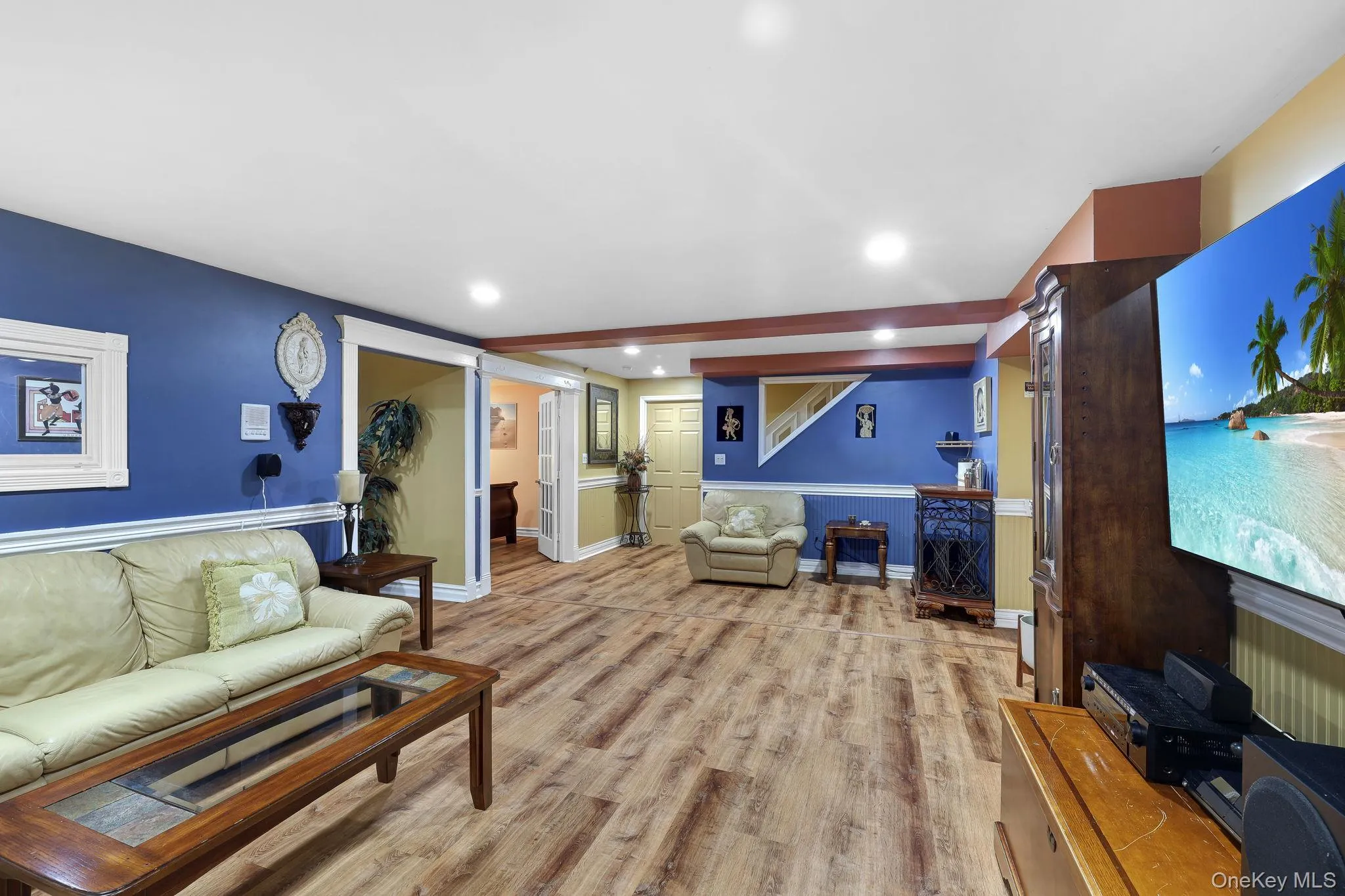 Spacious living area featuring wood-finish style flooring, recessed lighting, and crown molding Spacious living area featuring wood-finish style flooring, recessed lighting, and crown molding