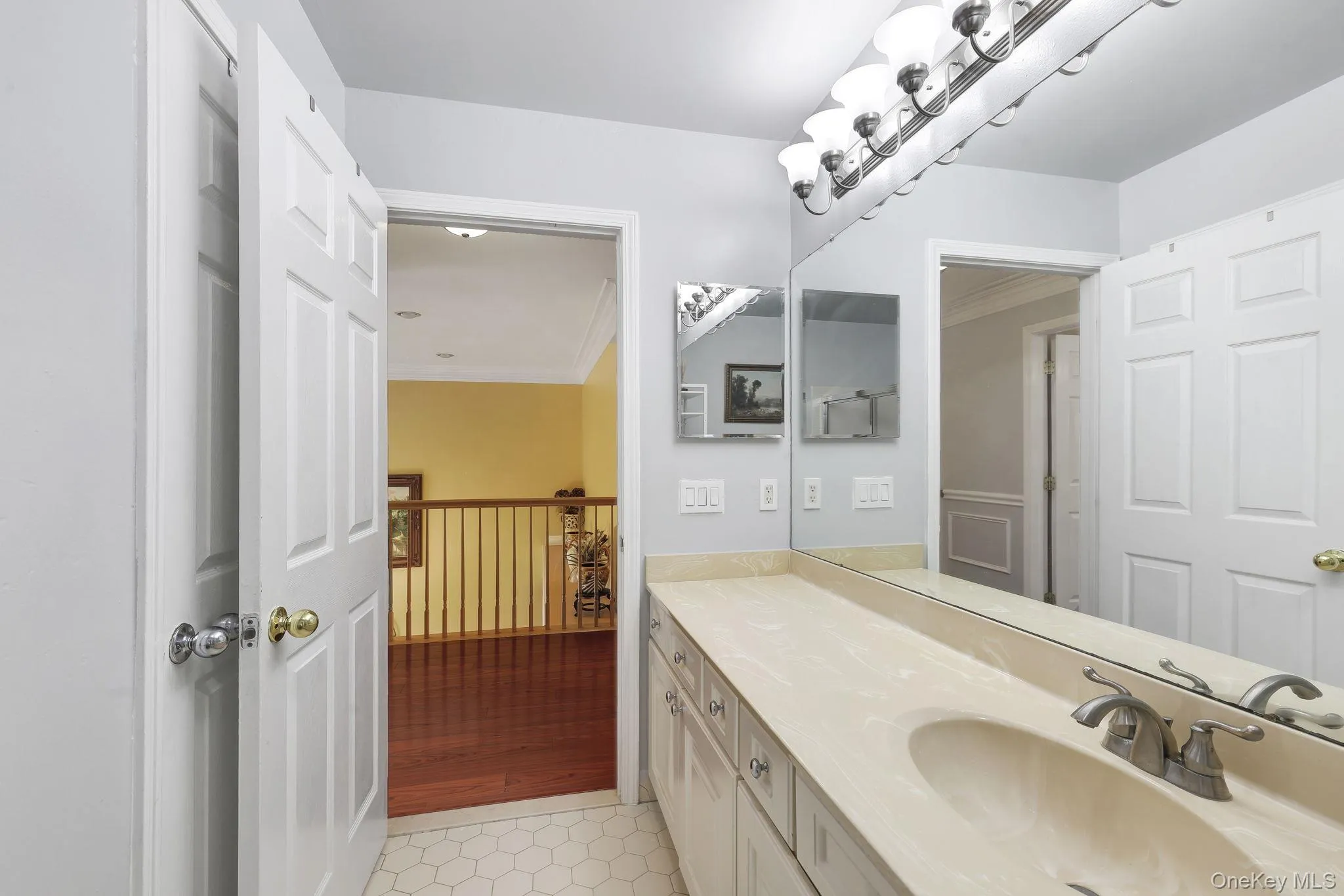 Upstairs hall bathroom vanity with an integrated sink, brushed nickel faucet, and a full-width mirror Upstairs hall bathroom vanity with an integrated sink, brushed nickel faucet, and a full-width mirror