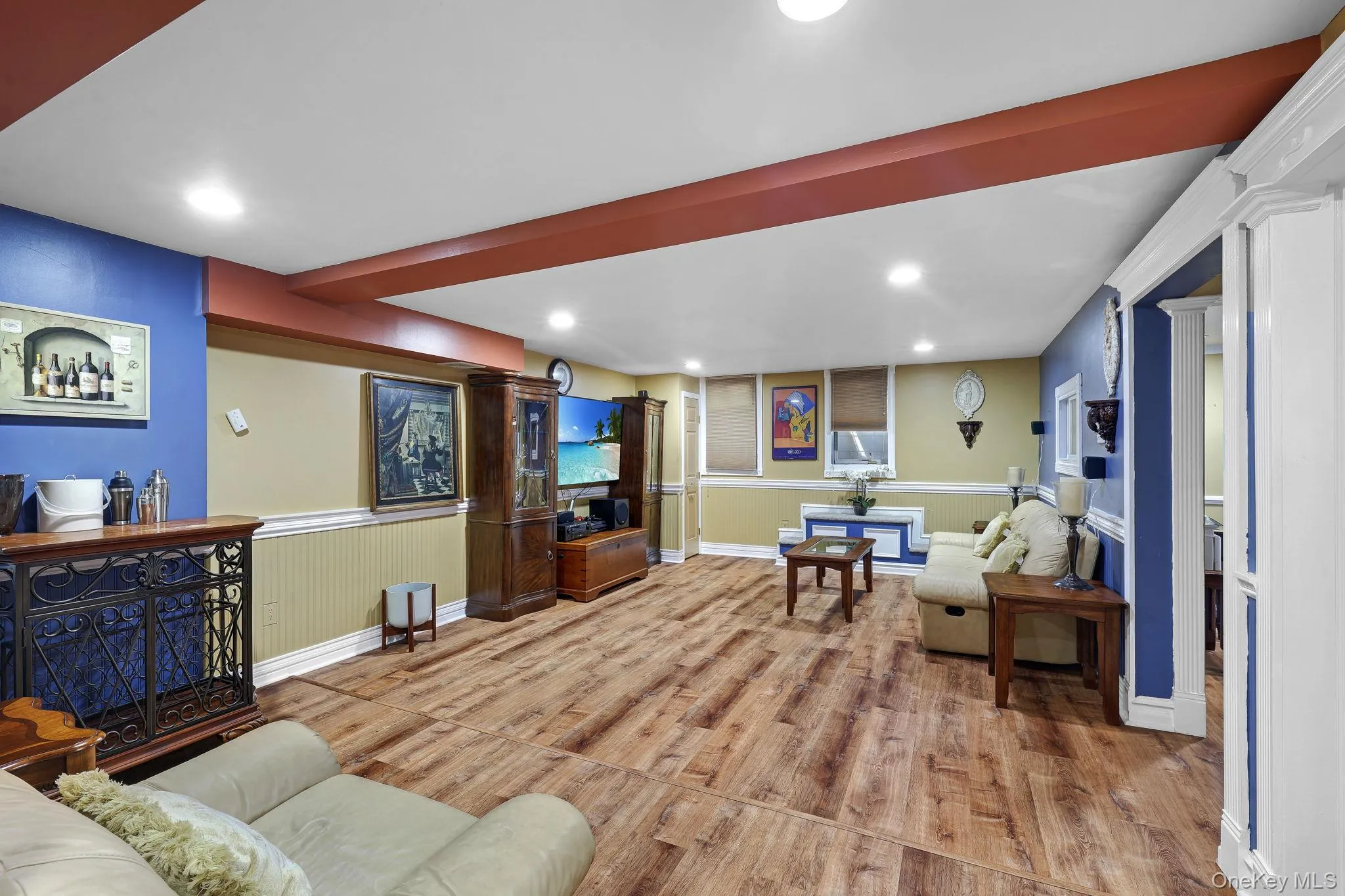 Expansive room featuring wood-finish style flooring, recessed lighting, and egress window Expansive room featuring wood-finish style flooring, recessed lighting, and egress window
