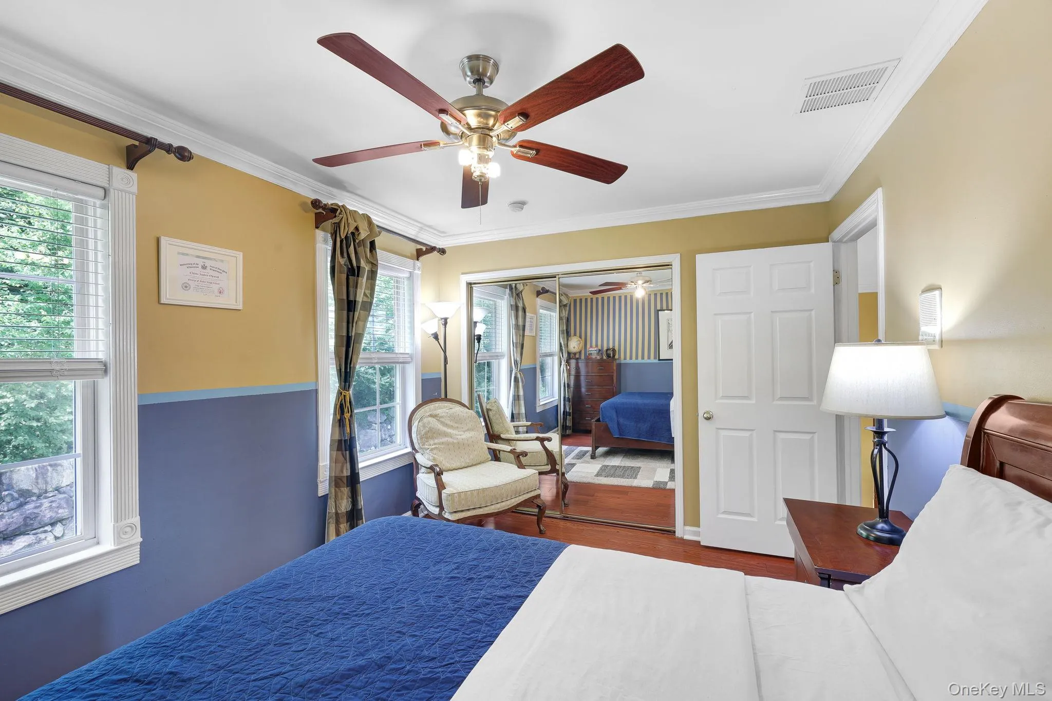 Bedroom featuring a ceiling fan with light kit, crown molding, and two windows with white blinds Bedroom featuring a ceiling fan with light kit, crown molding, and two windows with white blinds