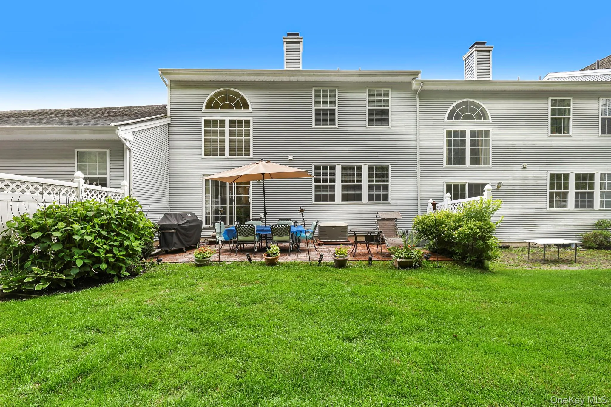 Expansive backyard featuring a manicured lawn, patio, and mature landscaping and privacy fence Expansive backyard featuring a manicured lawn, patio, and mature landscaping and privacy fence