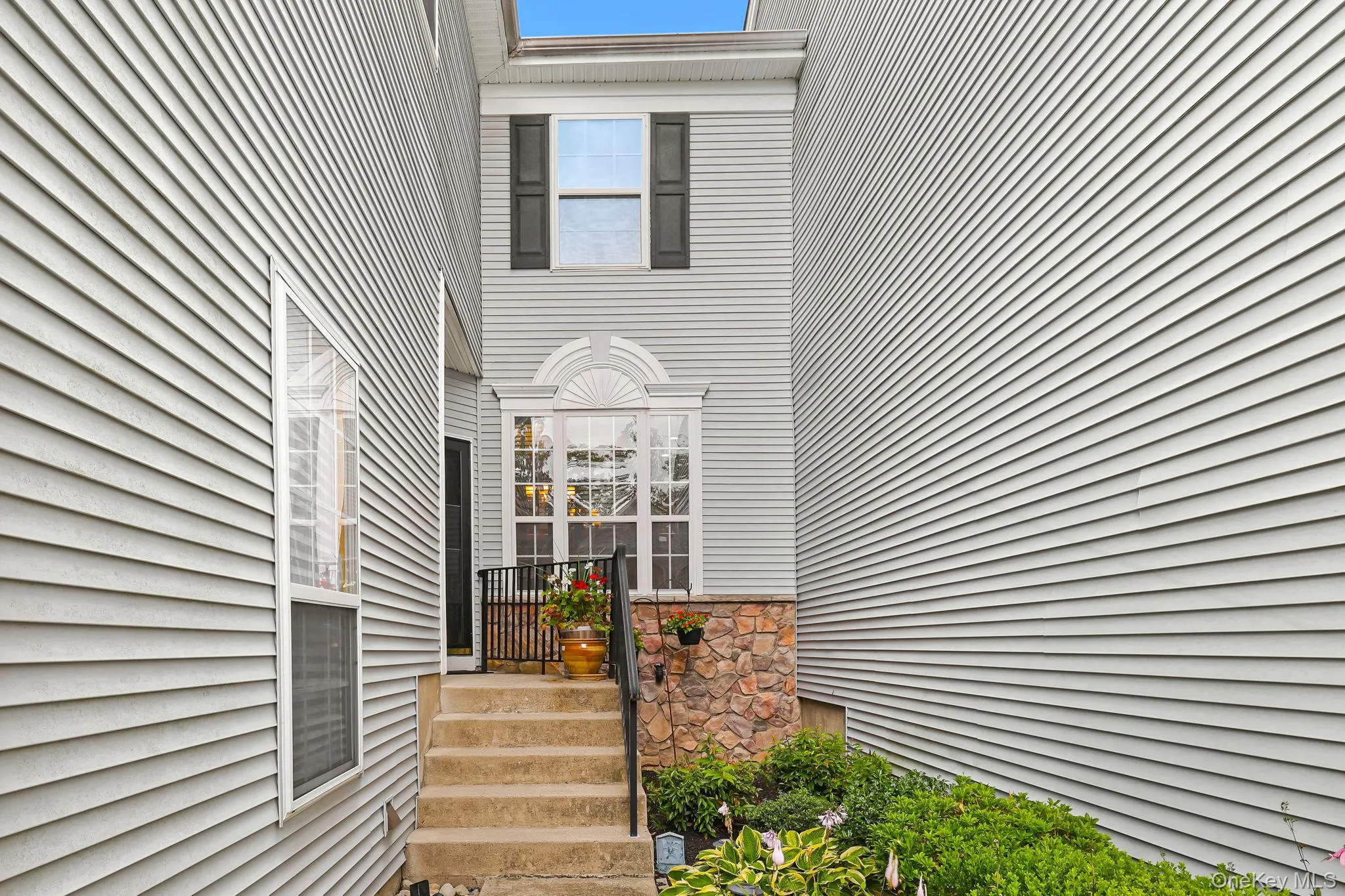 Private entry with lush greenery and large palladium window . Private entry with lush greenery and large palladium window .