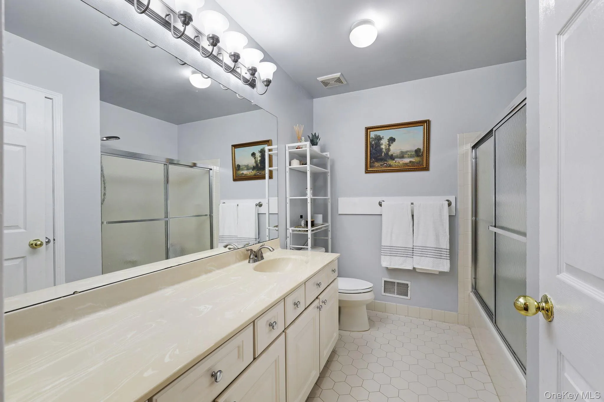 Upstairs hall bathroom, full-width vanity mirror reflecting a white paneled door Upstairs hall bathroom, full-width vanity mirror reflecting a white paneled door