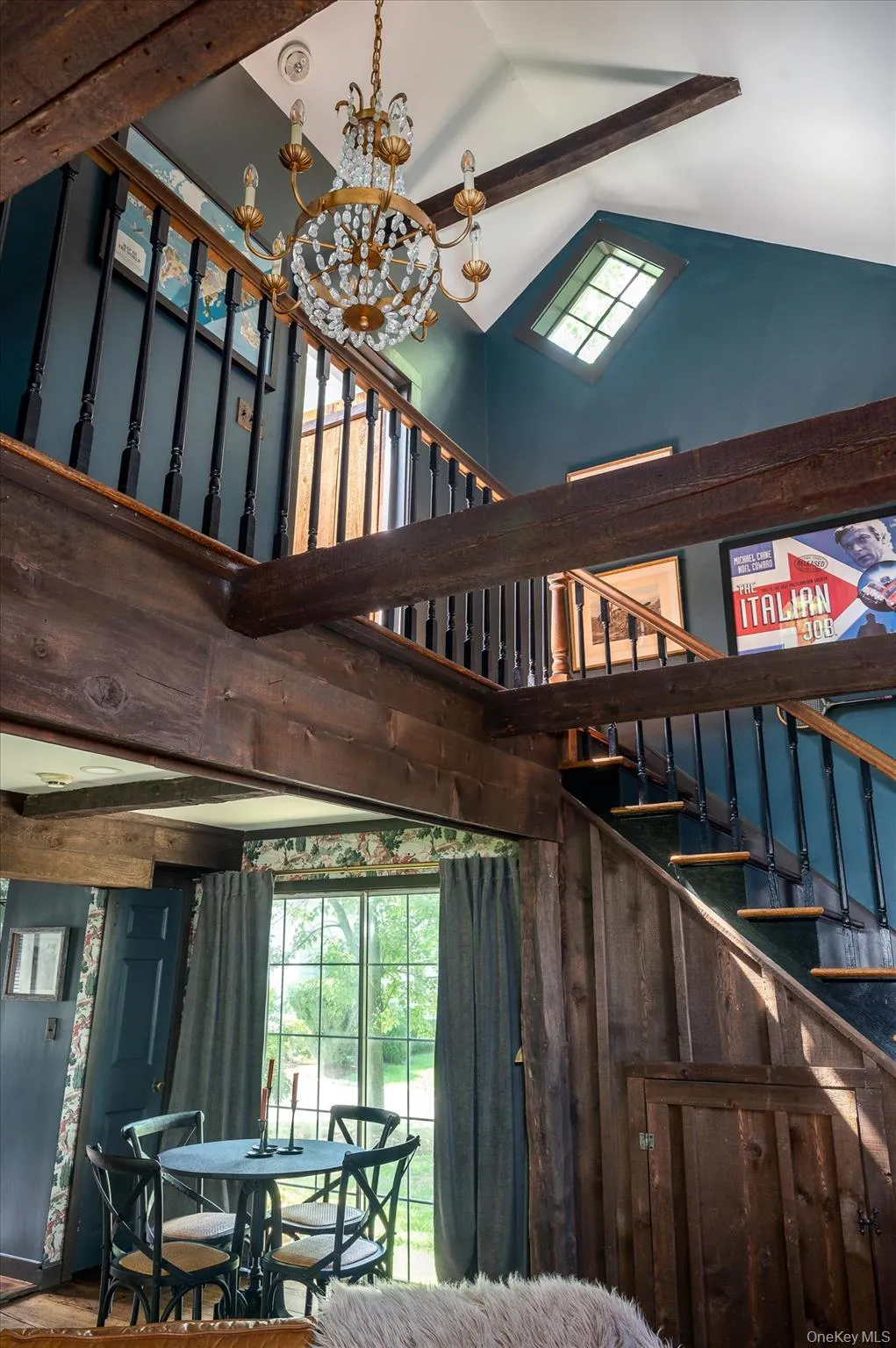 Stairs featuring high vaulted ceiling, a chandelier, and beamed ceiling Stairs featuring high vaulted ceiling, a chandelier, and beamed ceiling