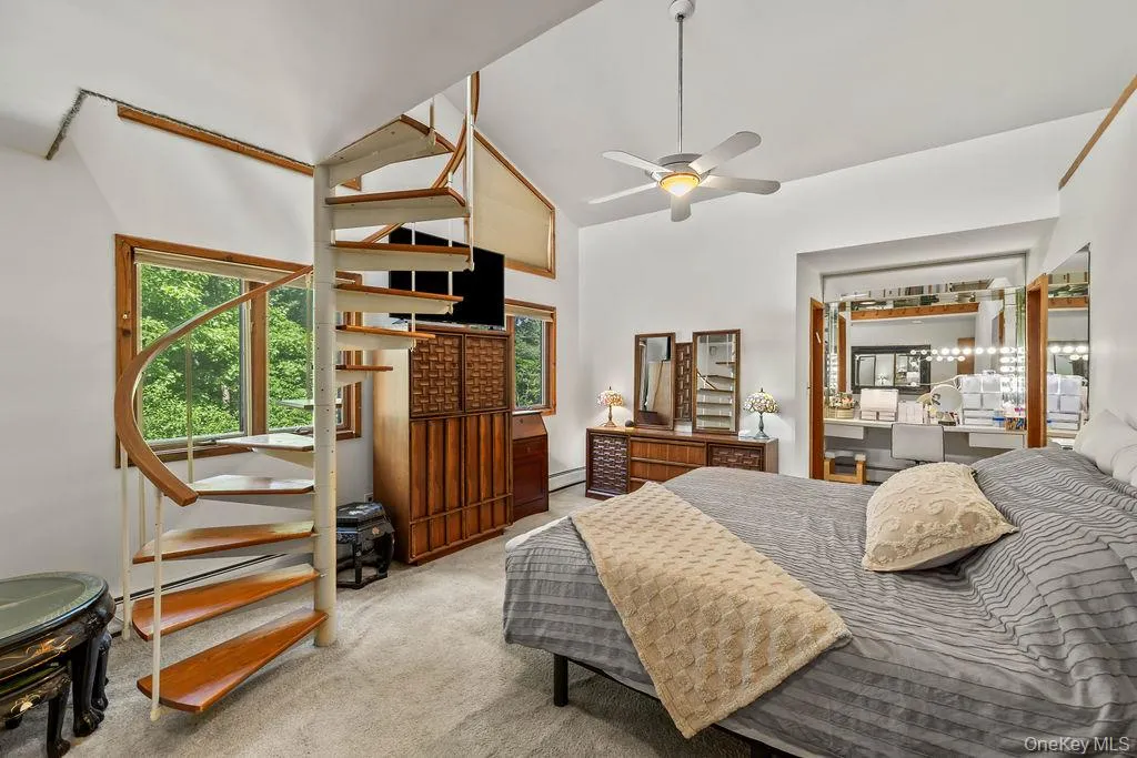 Primary Bedroom with Spiral Staircase to Loft. Dressing Area on opposite side. Walk-in closet to the left. Full Bathroom on right. Primary Bedroom with Spiral Staircase to Loft. Dressing Area on opposite side. Walk-in closet to the left. Full Bathroom on right.