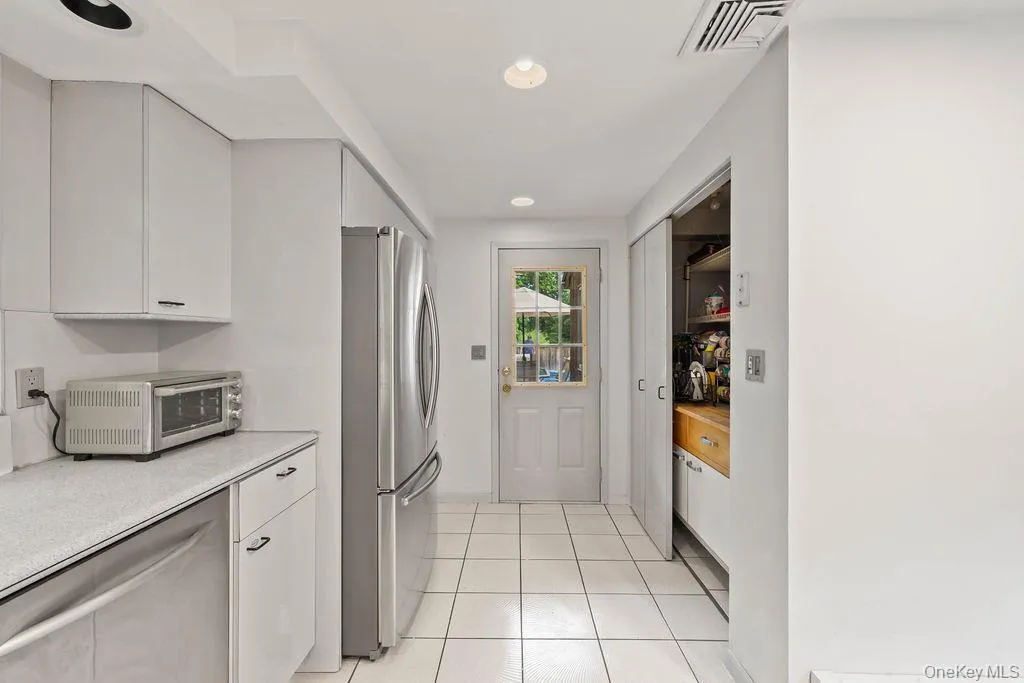 Kitchen with pantry and door to deck. (Pantry is plumbed for additional sink). Kitchen with pantry and door to deck. (Pantry is plumbed for additional sink).