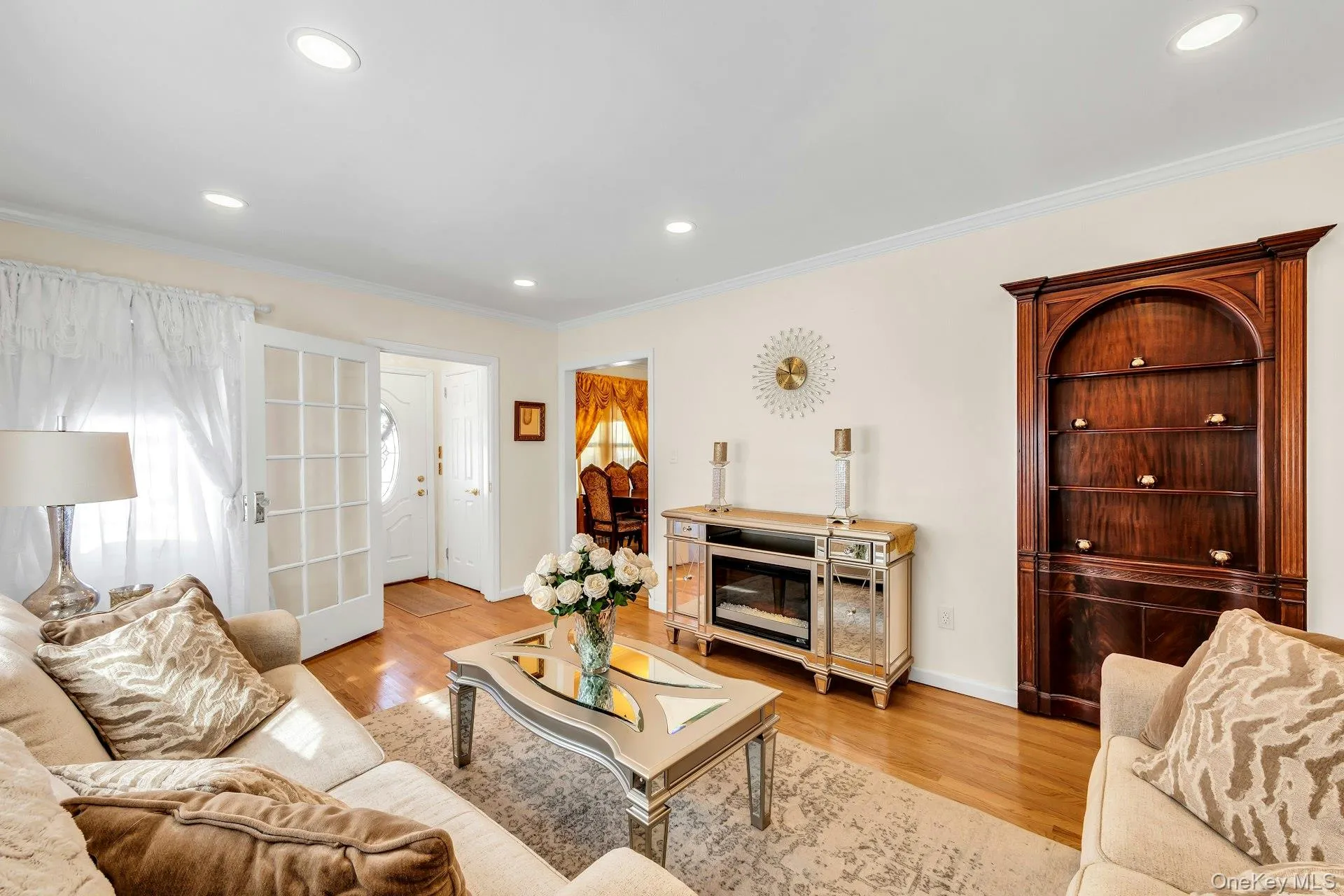 Living room featuring hardwood flooring, recessed lighting, crown molding, and French doors Living room featuring hardwood flooring, recessed lighting, crown molding, and French doors