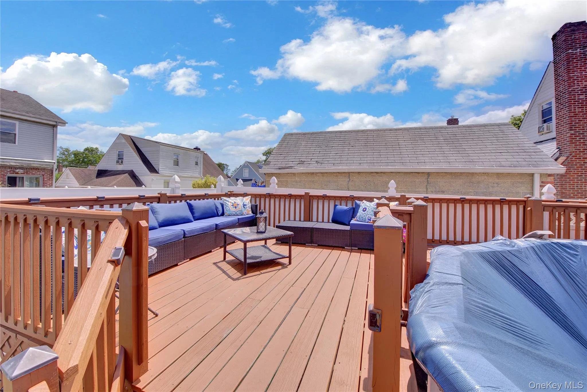Expansive rooftop deck featuring a finished wood surface, substantial wood railings, and a privacy fence Expansive rooftop deck featuring a finished wood surface, substantial wood railings, and a privacy fence