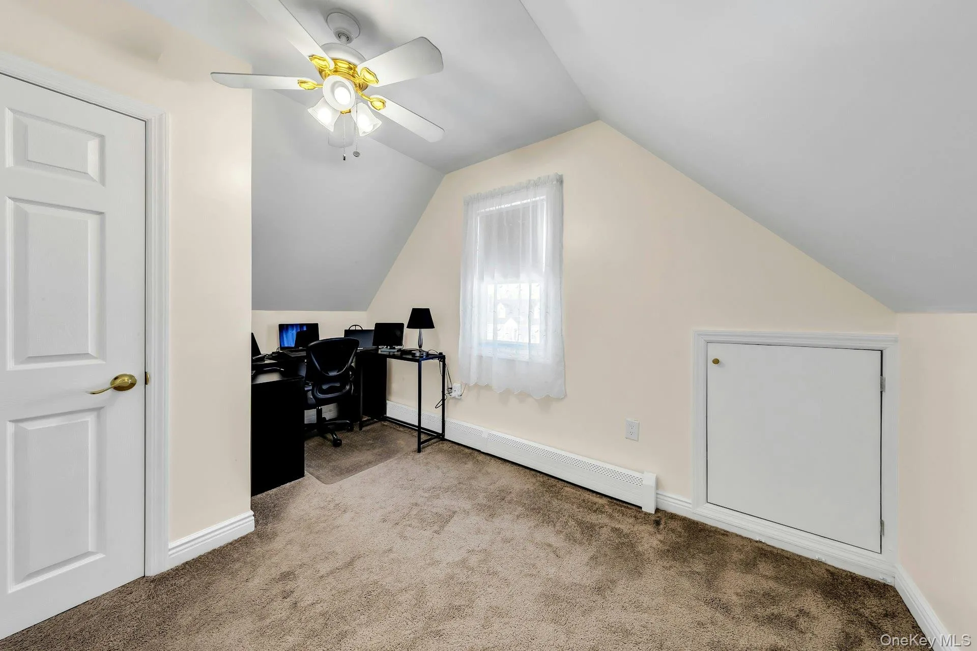 Carpeted room featuring sloped ceilings, a window with white sheers, a ceiling fan with integrated lighting, and a white paneled door Carpeted room featuring sloped ceilings, a window with white sheers, a ceiling fan with integrated lighting, and a white paneled door