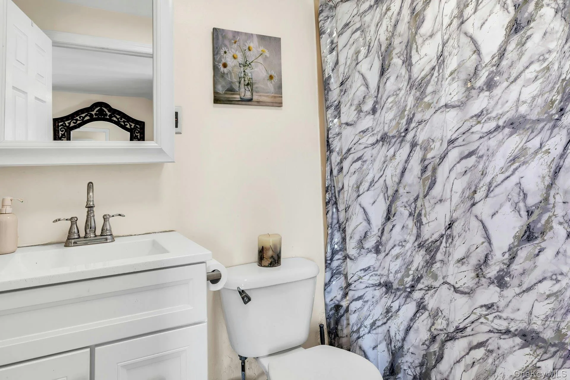 Vanity with an integrated sink, brushed nickel faucet, and white shaker-style cabinetry Vanity with an integrated sink, brushed nickel faucet, and white shaker-style cabinetry