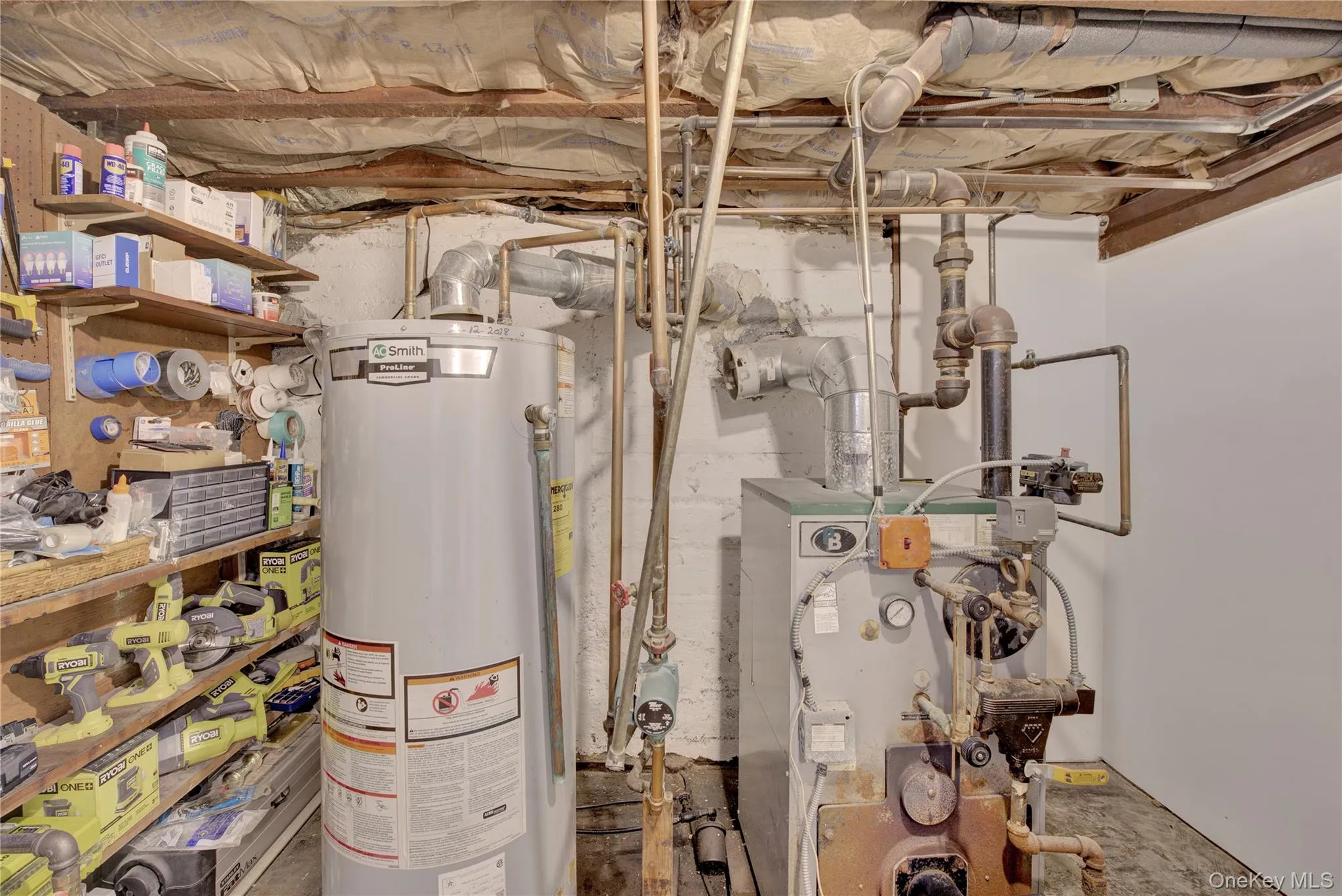 Utility area featuring a water heater, boiler system, and visible piping Utility area featuring a water heater, boiler system, and visible piping