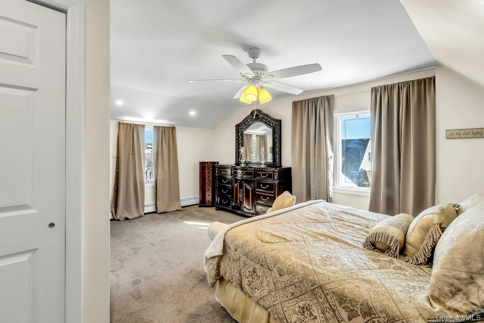 Carpeted bedroom featuring an angled ceiling, recessed lighting, and a ceiling fan with integrated lighting Carpeted bedroom featuring an angled ceiling, recessed lighting, and a ceiling fan with integrated lighting