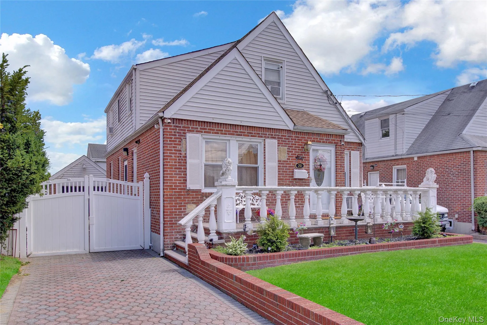 Brick and siding exterior featuring a decorative front porch with balustrade railing Brick and siding exterior featuring a decorative front porch with balustrade railing